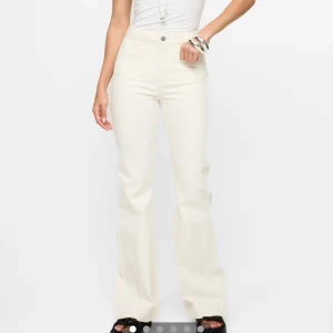 Vita bootcut jeans - Snygga vita bootcut jeans från bikbok med hög midja och raka ben som slutar i en lätt utsvängning. Byxorna har klassiska fickor både fram och bak samt råa kanter nertill för en trendig look. Perfekta att styla med sneakers eller sandaler. Avklippa så passat någon runt 155-165