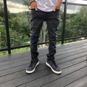 Svarta Replay jeans, slim fit - Säljer ett par svarta Replay jeans med snygg tvätt och klassiska detaljer. Jeansen har smal passform, fem fickor och coola Replay-loggor på fickorna. Perfekta för dig som gillar en stilren och modern look. Materialet är mjukt och stretchigt jeans.