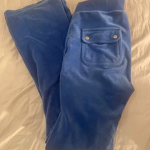 Blå juicy couture byxor - Juicy couture byxor sälj i en jättefin blå färg! Byxorna har två bruna fläckar (se bild 3) men annars i jättefint skick