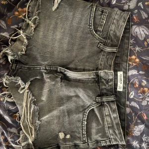 Svarta jeansshorts med fransar från Pull&Bear - Säljer ett par svarta/gråa  jeansshorts från Pull&Bear. Storlek 38 men små i storleken💕 Kolla in min bio innan ni köper!!
