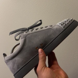 Grå sneakers Christian Louboutin helt nya! - Säljer mina helt nya Christian Louboutin för de är inte min stil. Louis flat saffian calf version c653. Knappt använda. Skick: 9,9/10.Storlek 43 passar också storlek 44. Medföljer box och dustbag. Vänligen hör av er vid frågor eller funderingar mvh Philip☺️