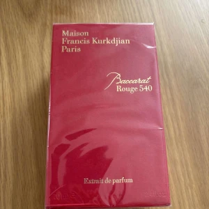 Baccarat Rouge 540 Extrait de Parfum - Lyxig parfym i elegant röd förpackning med guldfärgad text. Extrait de parfum-varianten av Baccarat Rouge 540, känd för sin intensiva och exklusiva doft. Perfekt för dig som vill sticka ut med en sofistikerad signaturdoft.