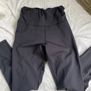 Svarta tights från SOC - Säljer ett par svarta tights från SOC med hög midja och dragsko i midjan. Perfekta för träning och sitter skönt på kroppen. Materialet är stretchigt och följsamt.