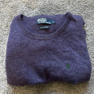 Lila ulltröja från Polo Ralph Lauren - Säljer en lila tröja från Polo Ralph Lauren i 100% lammull. Klassisk rund halsringning och diskret broderad logga på bröstet. Perfekt för dig som gillar stilrena och bekväma plagg.