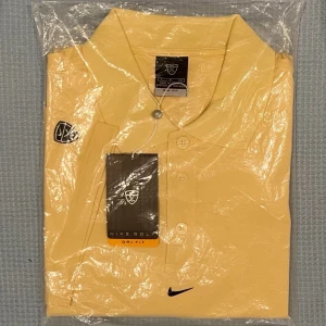 Nike - Gul Golf Dri-Fit pikétröja Strl S/M - Säljer en Nike Golf pikétröja med klassisk krage och tre knappar framtill. Tröjan har korta ärmar är tillverkad i ett luftigt material med Dri-Fit teknologi. Perfekt för ett funktionellt golfplagg eller en avslappnad dag ute. Nike-logotyp på vänster ärmoch på rygg 60% bomull, 40% polyester  Strl. S/M( Storleken är stor och passar bra även till L )