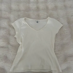 Vit v-ringad topp från Brandy Melville - Säljer en enkel och stilren vit topp från Brandy Melville!💕