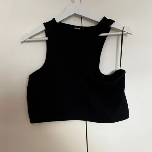 Svart croppad linnetopp från Bik Bok - Säljer en svart croppad linnetopp från Bik Bok. Toppen har breda axelband och är ärmlös med en tight passform. Perfekt att styla till jeans eller kjol.