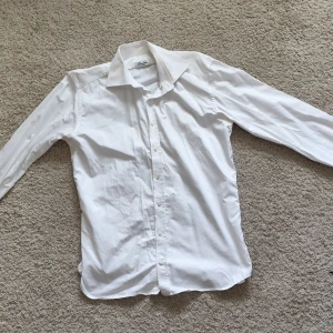Vit skjorta från Stenströms - Klassisk vit skjorta från Stenströms i slimline-modell. Skjortan har lång ärm, knappar framtill och en stilren krage. Perfekt för dig som gillar en smalare passform och tidlös stil.