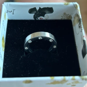 Edblad ring med kristaller  - Säljer en stilren s ring med infattade klara kristaller runt hela ringen. Ringen har en modern och minimalistisk design som passar perfekt för dig som gillar enkla men snygga smycken. St 16 finns i Majorna. 