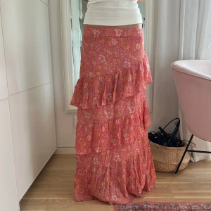 Rosa blommig volangkjol  - Säljer min supersöta somriga långkjol i rosa med blommigt mönster och volanger🌸Kjolen är i lagom längd för mig som är 173cm. Sparsamt använd och i superbra skick!