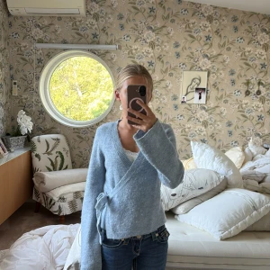 Ljusblå omlottkofta från Gina Tricot - Supermysig ljusblå omlottkofta från Gina Tricot. Den är knappt använd och är superskön. Köpte för ca 350 om jag minns rätt. Säljer för att den inte kommer till användning❤️