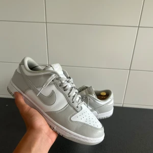 Nike Dunks Grå  - Säljer mina Nike Dunk Low Grey Fog i storlek 44. Fick dom i födelsedagspresent av min brorsa, han sa att de var köpta på Plick. Fick dem för cirka 2–3 månader sedan och endast använde dem 1–2 gånger. Nästintill nya. Tyvärr är de lite för stora för mig, annars hade jag behållit dem.