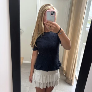 Mörkblå topp från Gina Tricot - Supersöt mörkblå topp från Gina Tricot med smockad framsida och volangkant nedtill. Är i storlek 170 men passar en S. Använd ca 2 gånger.