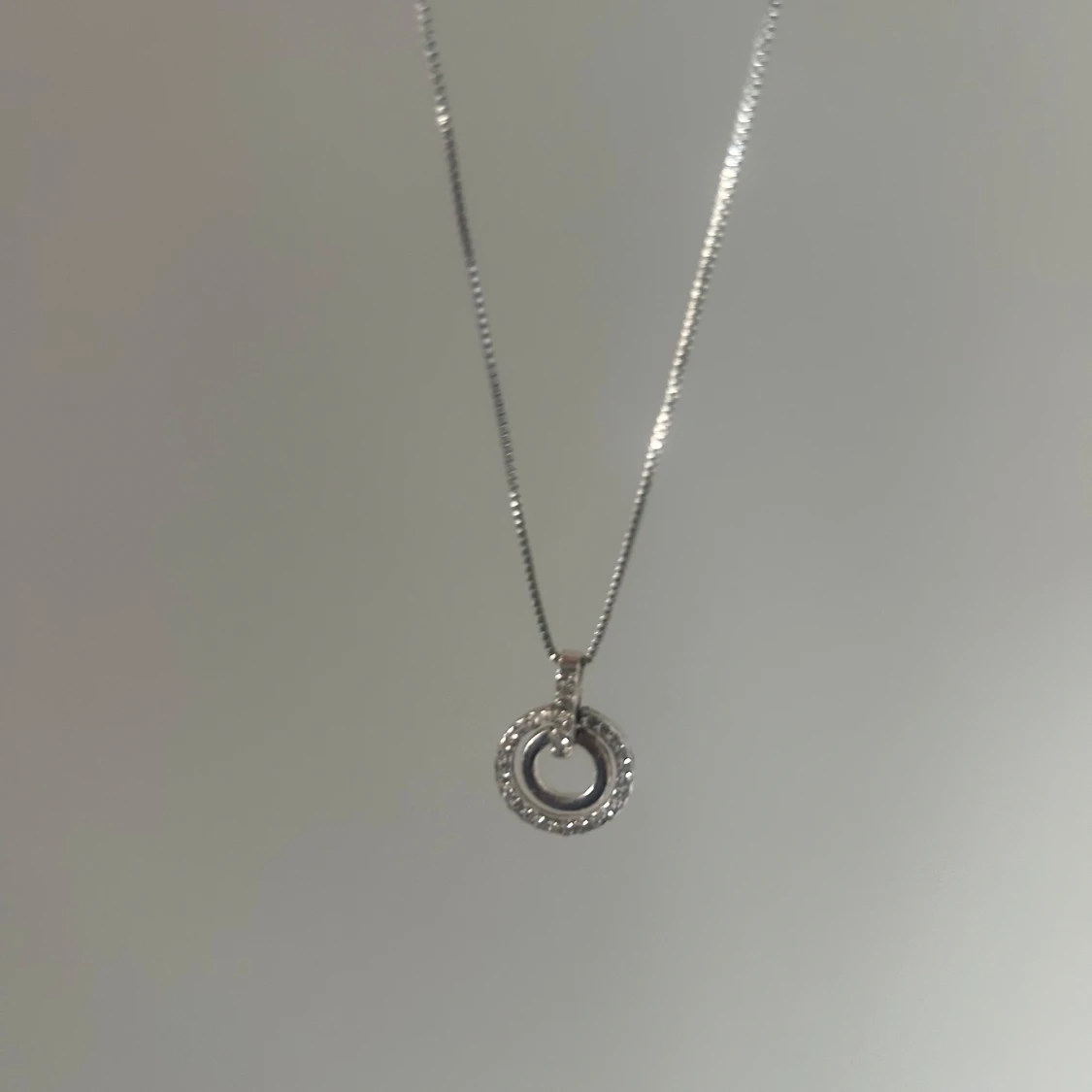 Silverfärgat halsband med cirkelberlock