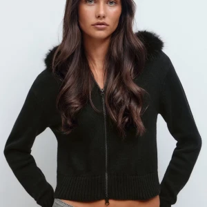 Svart stickad cardigan jacka  - Svart stickad cardigan jacka med dragkedja och huva kantad. Modellen är croppad med ribbade muddar och lång ärm. Köpte en storlek större för vill den skulle sitta lite lägre. Perfekt för dig som vill ha en mysig och snygg look.