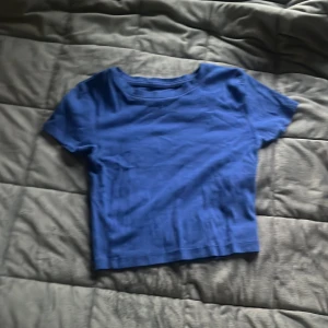 Blå ribbad croppad t-shirt från FSBN Sister - Säljer en blå croppad t-shirt från FSBN Sister i storlek XXS. Toppen är ribbad och har korta ärmar samt rund halsringning. Perfekt för dig som gillar en enkel men snygg stil.