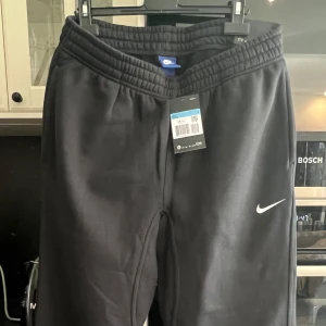 Svarta mjukisbyxor från Nike - Ett par helt nya Nike-byxor som aldrig har använts. Storlek medium, men upplevs som lite stora – viktigt att tänka på! Passar dig som ligger mellan M och L.