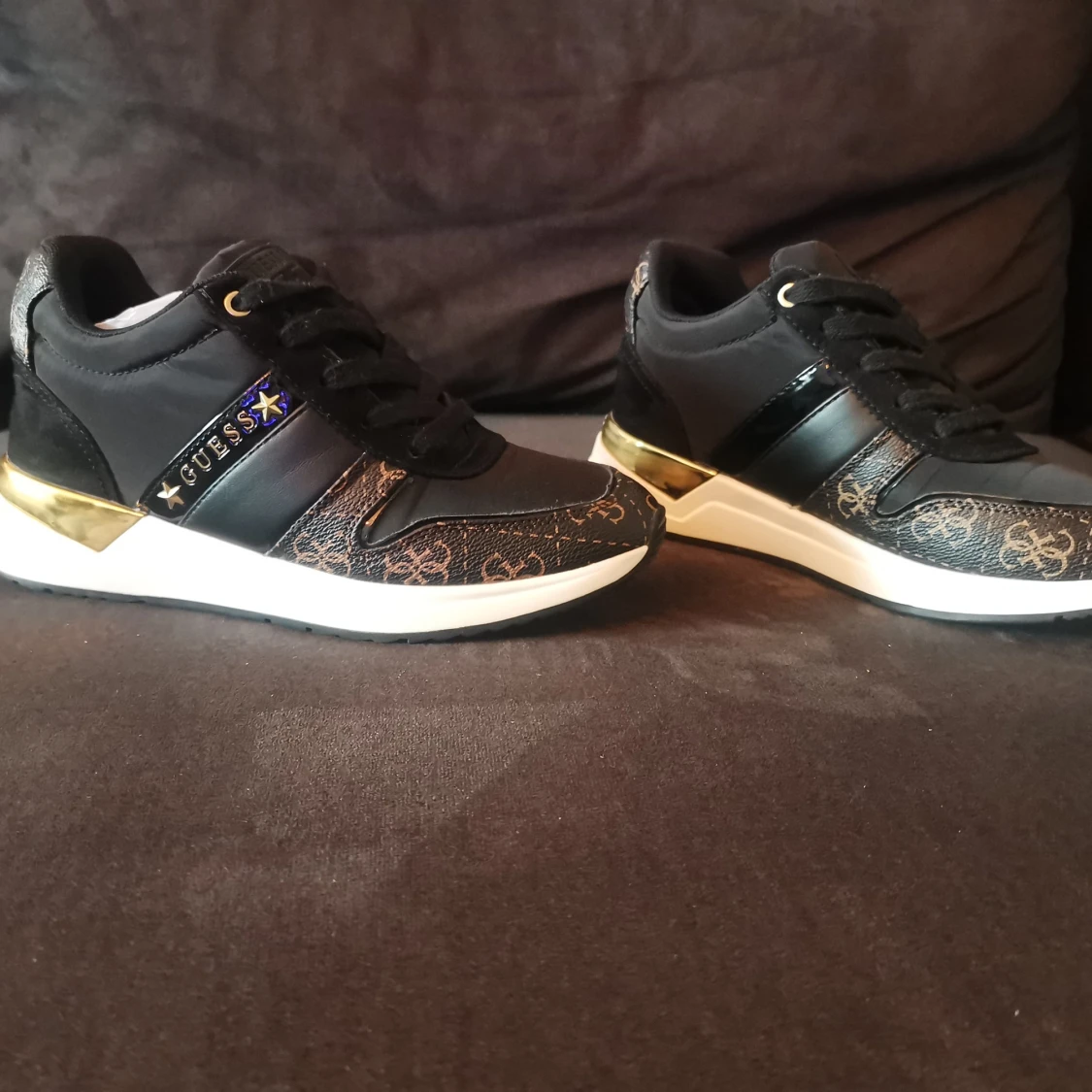 Svarta sneakers från Guess med gulddetaljer