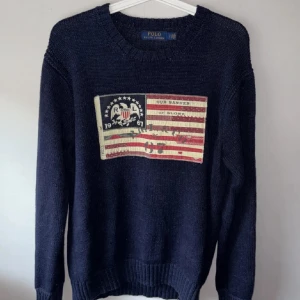 Ralph lauren flag tröja - säljer nu en fet och unik Ralph Lauren crewneck, storleken är 170 men sitter ungefär som M då dessa är väldigt stora i storleken, pris ej hugget i sten