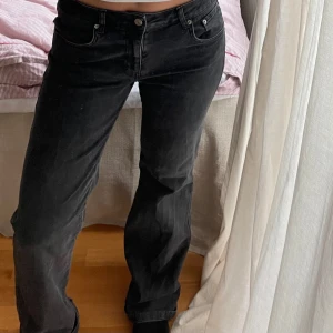 Svarta bootcut från Lager 157 - Grå/Svarta jeansbyxor från Lager 157 med klassisk femficksdesign och raka ben. Byxorna har normal passform och knappgylf. Perfekta för en avslappnad stil och enkla att matcha med olika toppar.