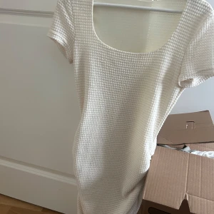 Vit ribbad kortklänning - Kort, ända till låren. Sitter tajt men tillräckligt löst. Väldigt skön