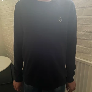  Morris sweatshirt  - Säljer en Mörkblå långärmad tröja från Morris med rund halsringning och en liten broderad logga på bröstet. Perfekt för en stilren och enkel look. Passar dig som gillar klassiska plagg med diskreta detaljer. Storlek S 