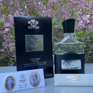 Creed Aventus Eau de Parfum 100ml - Lyxig parfym från Creed, Aventus, i en elegant genomskinlig glasflaska med svart och silverdetaljer. Flaskan rymmer 100 ml och kommer med originalförpackning och informationskort. Doften är ikonisk och exklusiv.