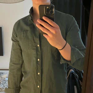 Mörkgrön skjorta från Zara i linne  - Säljer en  mörkgrön skjorta från Zara i linne 