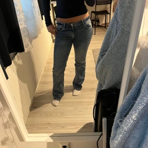 Blå raka jeans - Säljer ett par klassiska blå jeans med normal passform och raka ben. Jeansen stängs med dragkedja och knapp. Perfekta till vardags och lätta att matcha med olika toppar.