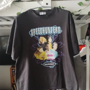 Svart Speedhunters t-shirt från Balenciaga  - Cool svart t-shirt från Balenciaga med stort Speedhunters-tryck och färgglad grafik på framsidan. Baksidan har turnélista-tryck i vitt. Klassisk passform och rund hals. Perfekt statement-plagg för dig som gillar 