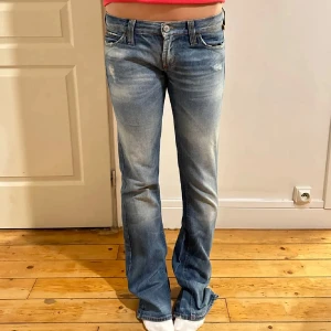 Blå bootcut jeans  - Snygga blå jeans med bootcut passform och lätt slitna detaljer framtill. 