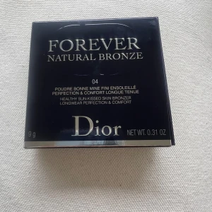 Dior Forever Natural Bronze 04 Tan Bronze - Lyxig bronzer från Dior i nyansen 04 Tan Bronze. Kommer i en rund, quiltad beige dosa med silverfärgad CD-logga. Ger en solkysst look och är perfekt för att framhäva ansiktskonturer. Innehåller 9g puder.