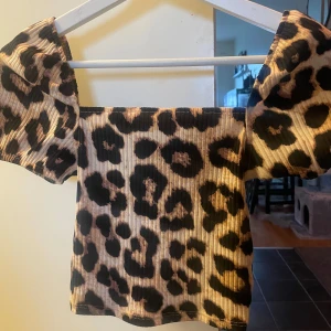 Leopardmönstrad croppad topp - Säljer en croppad topp med leopardmönster och ribbad struktur. Toppen har korta puffärmar 