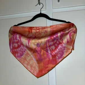 Tubtop - Säljer en tunn och glansig tubtop i siden med mönster i orange, rosa och lite gult