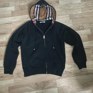 Burberry zip up hoodie svart - Säljer en svart hoodie från Burberry i storlek S-M. Perfekt för dig som gillar lyxiga streetwear-märken. Mycket bra skick.