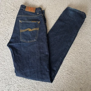 Nudie Jeans Grim Tim - Tja, säljer ett par riktigt fräscha mörkblå Nudie Jeans Grim Tim i storlek 30/32. Säljer eftersom jeansen är för små för mig. Knappt använda och väldigt snygg tvätt. Pris går att diskuteras. Hör av dig vid frågor!