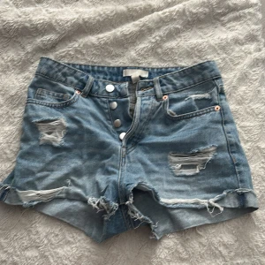 Blå jeansshorts med slitningar - Snygga jeans shorts. De är i storlek 34 men skulle säga 36 då de passar mig som är 36