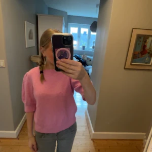 Rosa stickad tröja med puffärm - Säljer en söt rosa stickad tröja med puffärm och rund halsringning. Tröjan har en mjuk och fluffig känsla, och är perfekt för dig som gillar färg. Passar till både jeans och kjol.