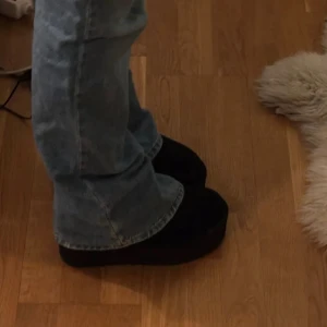 Svarta UGG boots med platåsula - Säljer ett par svarta UGG boots med hög platåsula. Skorna är i mocka och har klassisk UGG-logga bak på hälen. Perfekta för dig som vill ha både komfort och lite extra höjd i vardagen. Superfint skick, knappt använda. 900:-