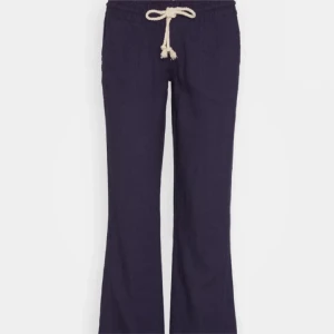 Mörkblå linnebyxor från Roxy  - Säljer ett par mörkblå, lågmidjade linnebyxor från Roxy med vit snörning i midjan. Byxorna har avslappnad passform och är perfekta för varmare dagar. Nypriss: 600kr, nästan helt oanvända. Kontakta mig för fler bilder eller vid intresse!💕