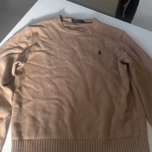 Beige tröja från Polo Ralph Lauren - Säljer en stilren beige tröja från Polo Ralph Lauren. Tröjan har långa ärmar och en diskret logotyp på bröstet. Perfekt för en klassisk och avslappnad look. den är ny tvättad och använd cirka 5 gånger 