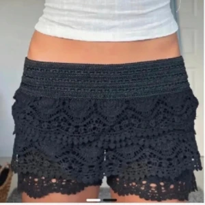 Svarta spets shorts - Snygga svarta shorts med vacker spetsdesign och elastisk midja. Perfekta för en somrig look med en touch av elegans. Passar bra till en enkel topp eller blus.