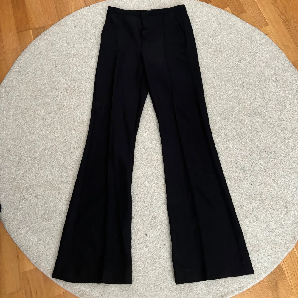 Svarta kostymbyxor med tight passform som går ut längst ner, likt bootcut byxor. . Farkut & Housut.