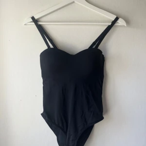 Svart Body - Fin svart body att ha till vardags eller på fest😊Ingen lapp i vart den är ifrån eller vilken storlek men skulle gissa på 75A eller 70B🥰Inte använd så mycket, så i väldigt bra skick❤️‍🔥Skriv för fler bilder!!(banden går att ta av)