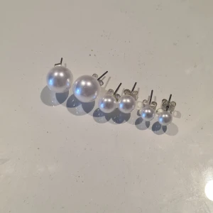 Pärlörhängen i olika storlekar - Säljer ett set med tre par klassiska pärlörhängen i olika storlekar. Perfekta att mixa och matcha för olika looks. Fästen i silverfärgad metall och vita pärlor ger en tidlös och elegant känsla💕