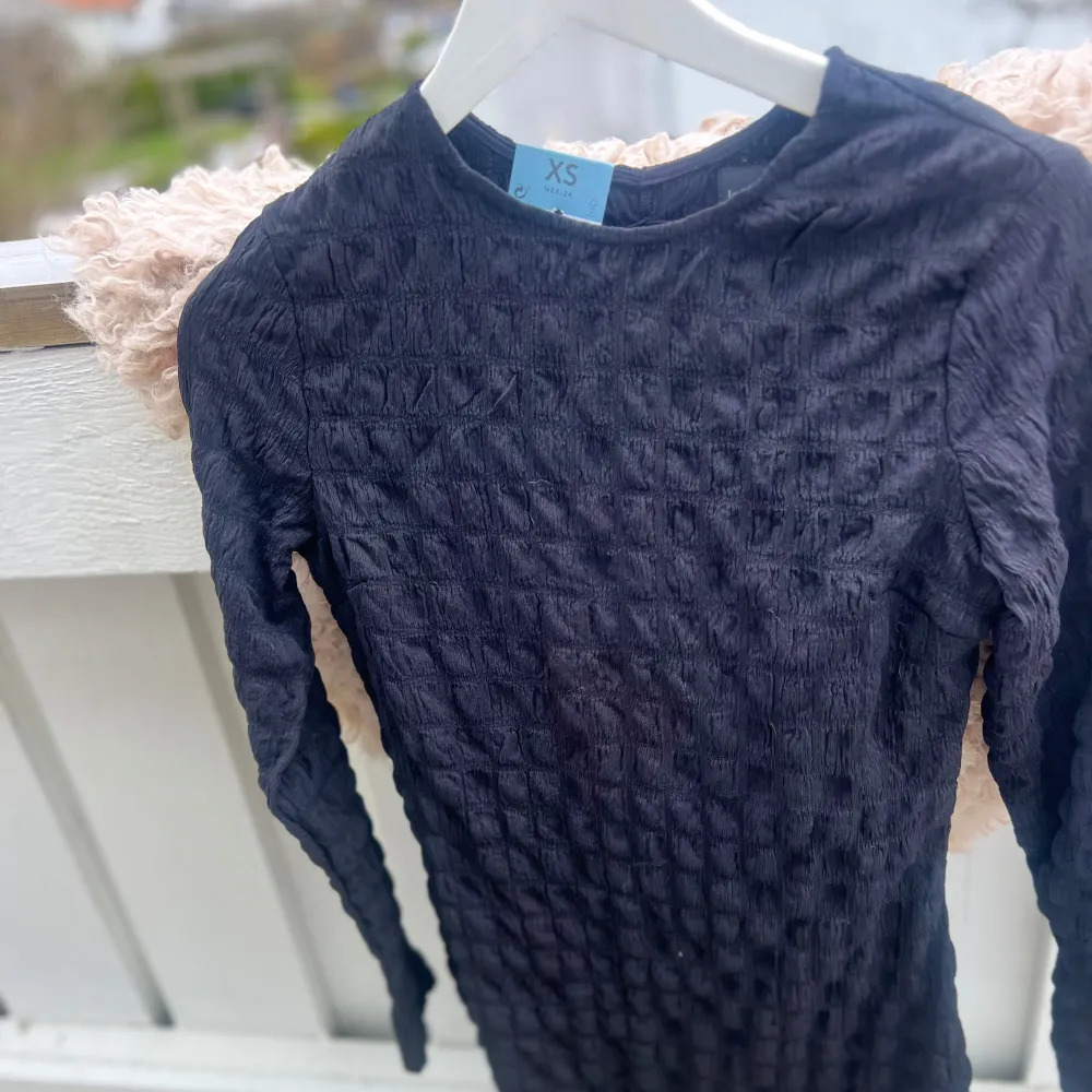 Säljer en svart långärmad klänning från Lefties i storlek XS. Toppen har en unik, skrynklig struktur i materialet och en rund halsringning. Perfekt att styla till olika outfits för en trendig look. Bak vid nacken så har den en ihålig design så man visar lite av nacken. SKRIV TILL MIG INNAN NI KÖPER!!. Mekot.