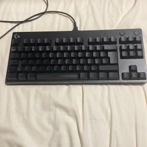 Logitech G Pro mekaniskt tangentbord med RGB-belysning - Säljer ett Logitech G Pro mekaniskt tangentbord med RGB-belysning. Tangentbordet har blå switchar och kompakt design utan numerisk del. Svart färg med tydlig Logitech-logga i hörnet. Perfekt för gaming och skrivande.