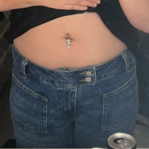 Blå jeansbyxor med flare ben - Säljer ett par klassiska blå jeansbyxor från 157 i storlek L för 157kr! short length. Byxorna har flare ben, låg midja och dubbla knappar framtill. Perfekta för dig som gillar en enkel och tidlös jeansstil. Hör av er innan köp🤍