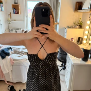 Prick klänning med smala axelband - Säljer en söt prickig klänning med smala korsade axelband i ryggen. Skön sidenkänsla i materialet!