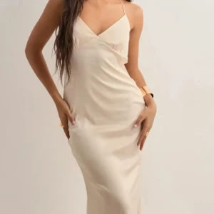 Balklänning med öppen rygg - Elegant champagnefärgad klänning med smala axelband och öppen rygg. Klänningen har en v-ringad design och knytning i ryggen. Klänningen är från Nellys nya bal kollektion och jag har aldrig använt den. Köpte fel storlek och råkade ta bort lappen. Pris kan diskuteras💓champagne färgad. Nypris 899